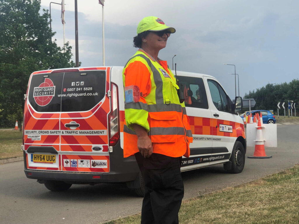 a traffic control officer standing next to the right guard traffic control van
