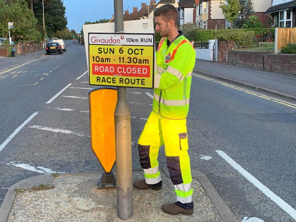 a man standing next to a stop sign